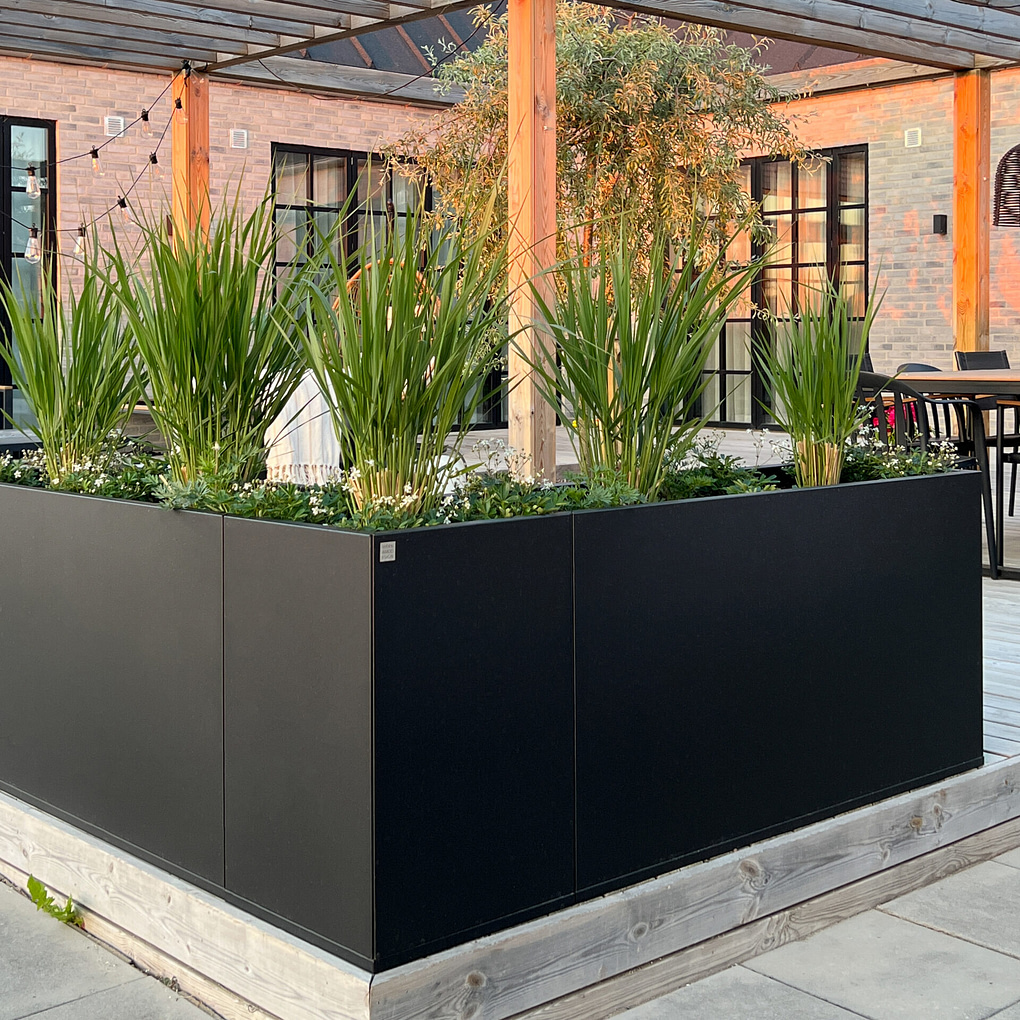 Plant Box Vinkel från Wernamo Design. Rumsavdelare eller insynsskydd på uteplatsen. Svart stor blomkruka, planteringskärl.