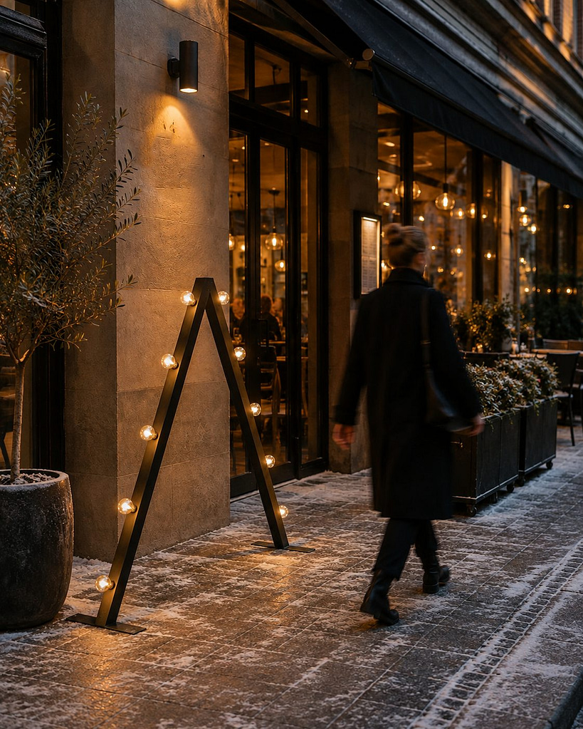 Svart Ljuseveka placerad utanför i entré till restaurang.