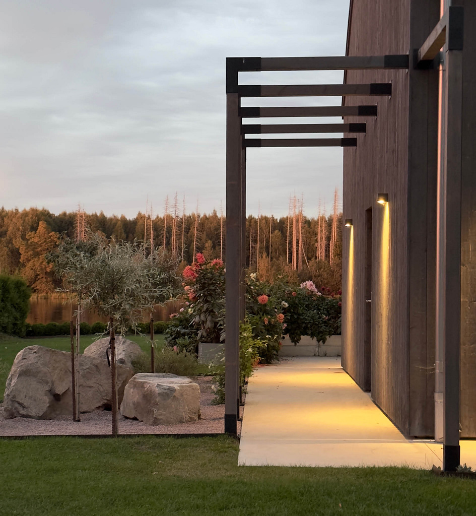 Pergolagång i trä med svarta pergolabeslag från Wernamo Design vid modern villa