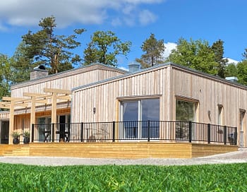 Staket Herrestad framför modernt hus i trä