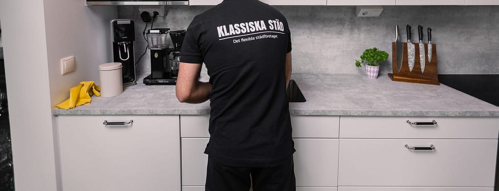 Man i Klassiska Städ-t-shirt rengör kök.