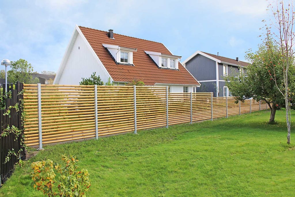 Staket Drömminge i galvaniserat utförande, placerat längs tomtgräns mot granntomt.