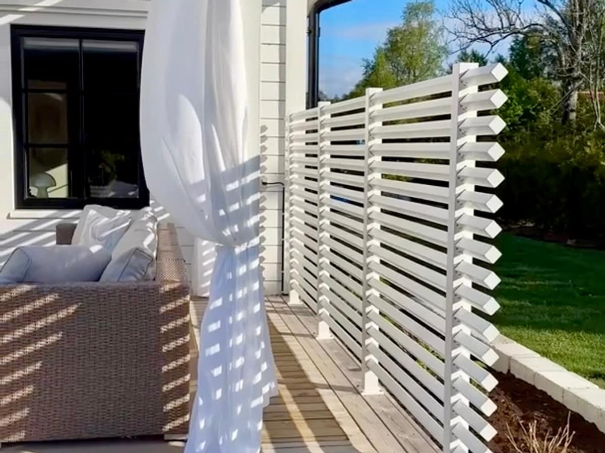 Avskärmnings vägg på uteplatsen av ett vitt staket.