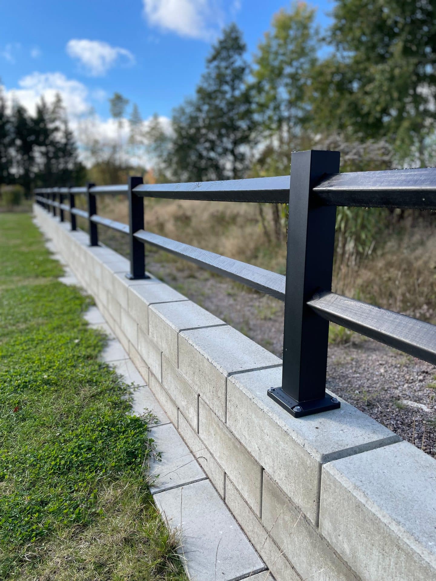 Sort lavt hegn på en væg.