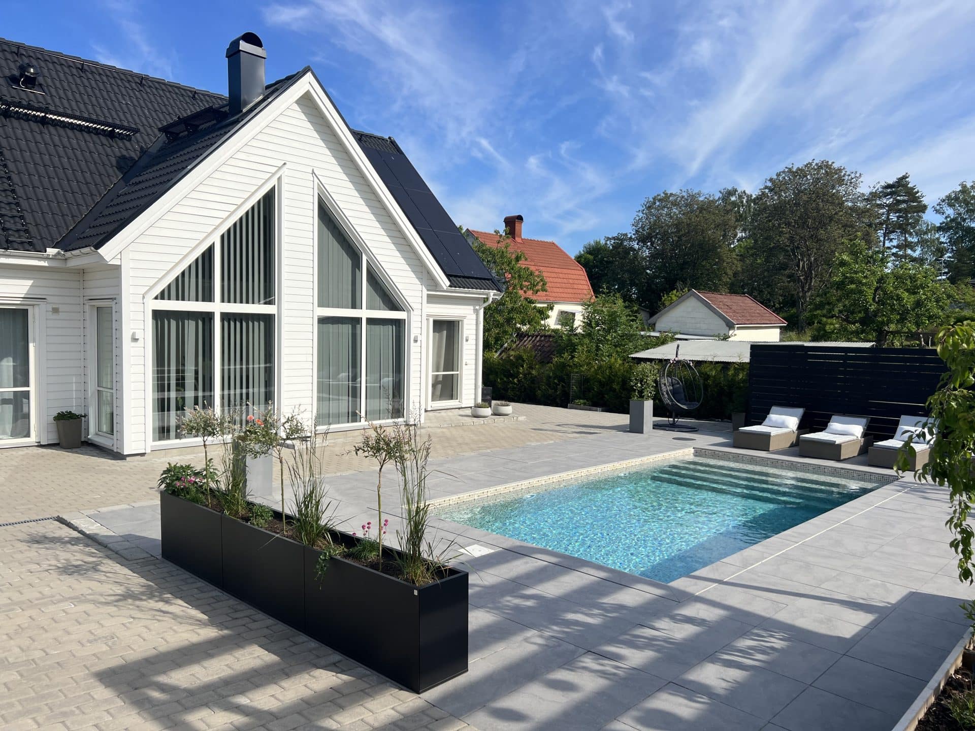 Ett långt planteringskärl vid en pool. Plant Box Flex från Wernamo Design.