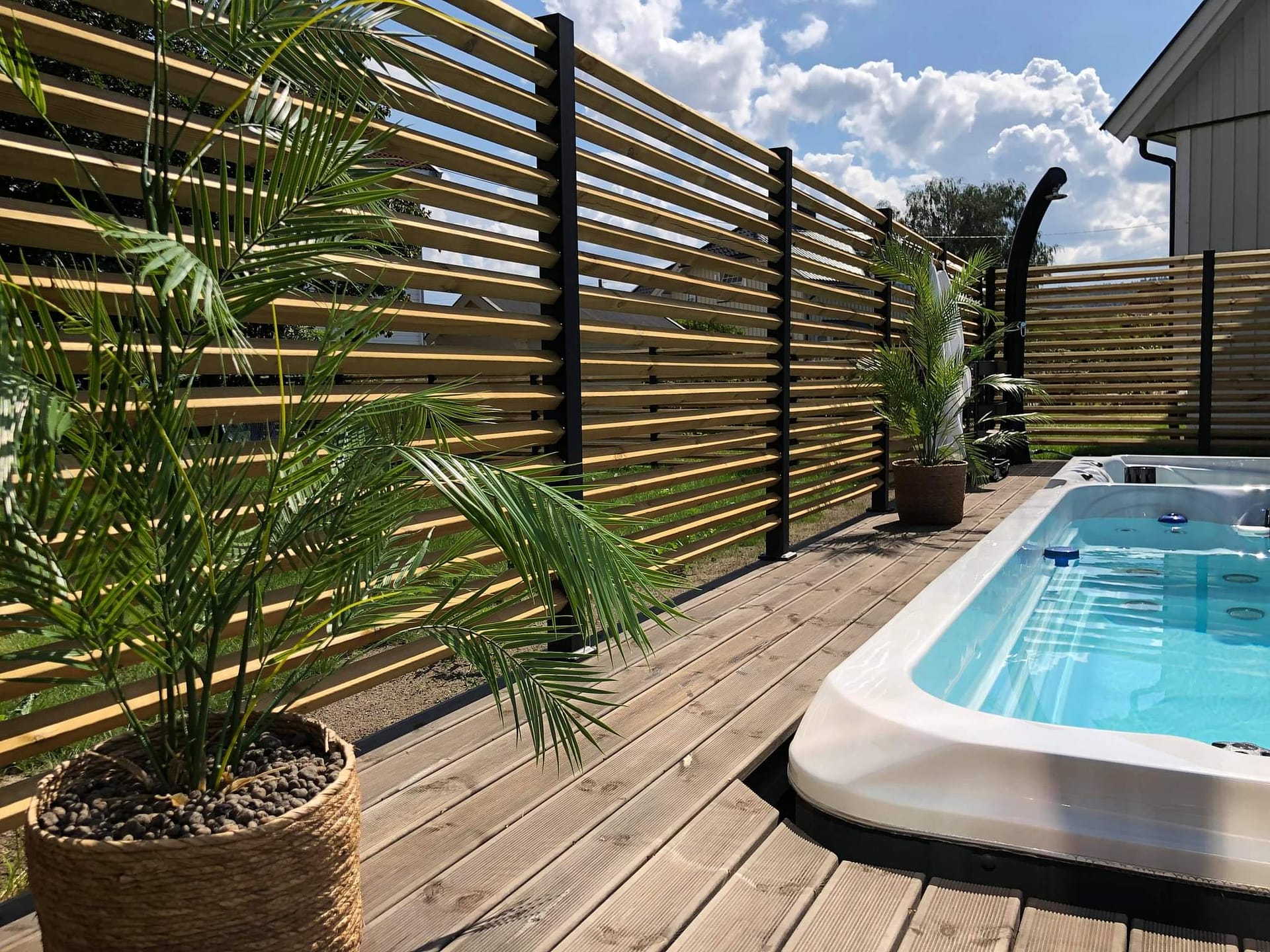 Højt hegn omkring et spabad.