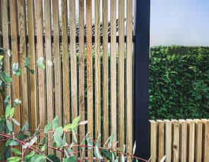 Närbild av ribbstaket Borgen som har svart stolpe och träribbor