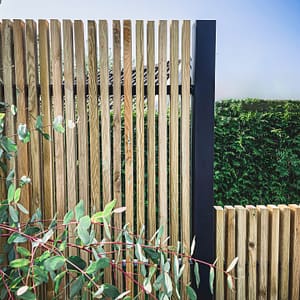 Närbild av ribbstaket Borgen som har svart stolpe och träribbor