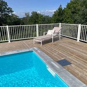 Hvidt metalhegn omkring en pool.