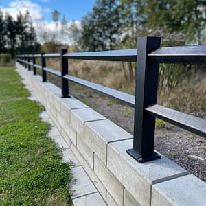 Sort lavt hegn på en væg.