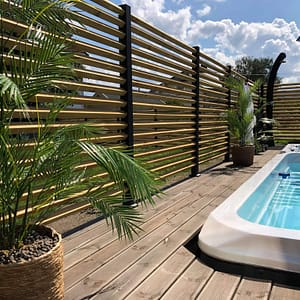 Højt hegn omkring et spabad.