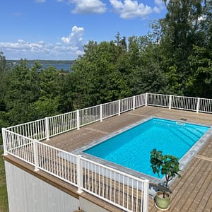 Vitt staket Herrestad ramar in en pool.