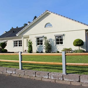 Lågt staket med staketstolpar av metall och två liggande träreglar.