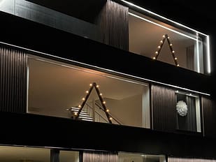 Belysning i stort fönster. Led belysning. Juldekoration, stor julbelysning, stor ljusstake.