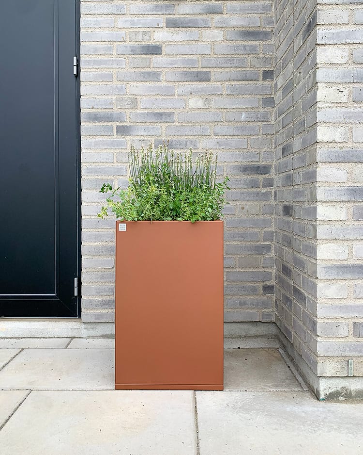 Snygg stor utekruka i corten vid en entré.